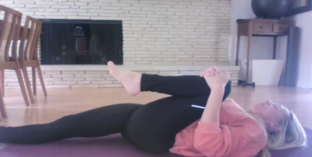 Woman doing Pilates stretches on her Pilates mat.