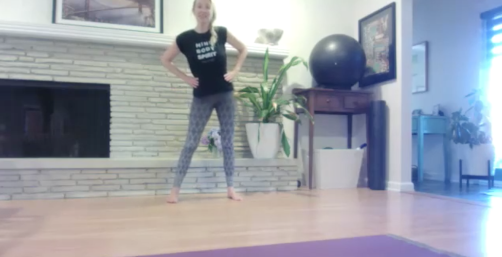 Woman doing standing Pilates exercises.