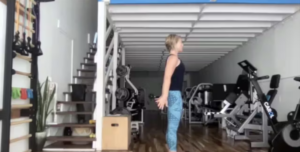 Woman doing standing Pilates exercises.