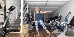 Woman doing standing barre and Pilates exercises in a gym.