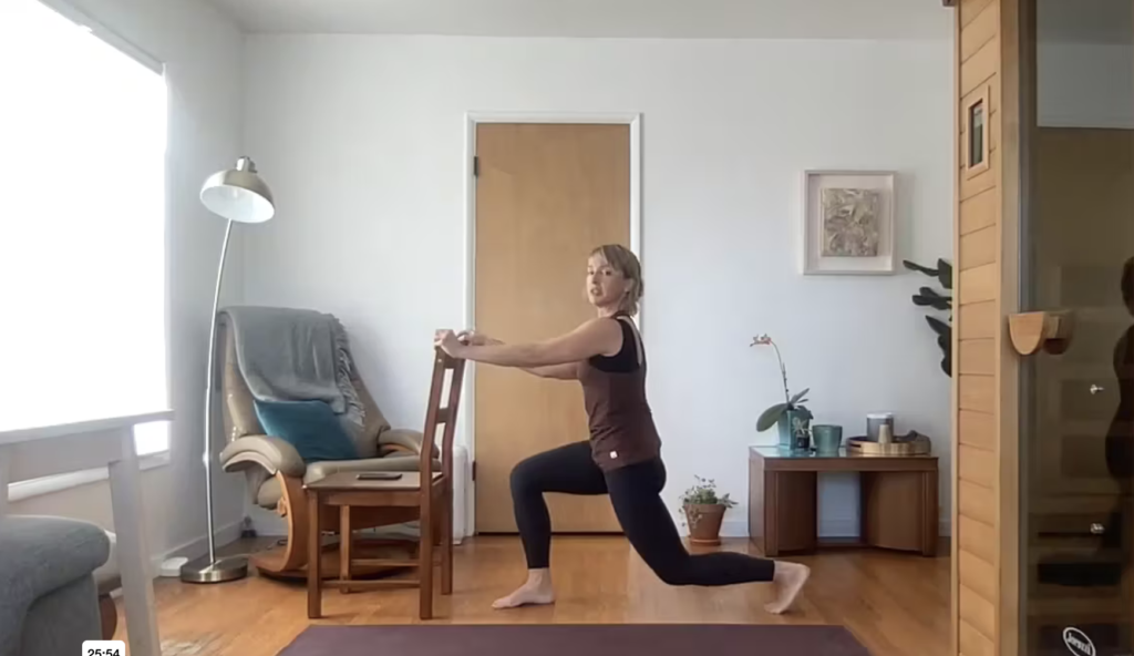 Woman doing Pilates lunges with a chair.