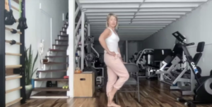 Woman doing standing Pilates exercises.