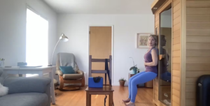 Woman doing Pilates exercises standing against the wall.