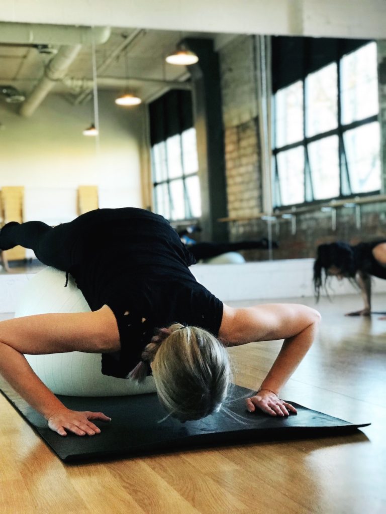 Woman doing a Pilates Pushup in a Pilates studio.