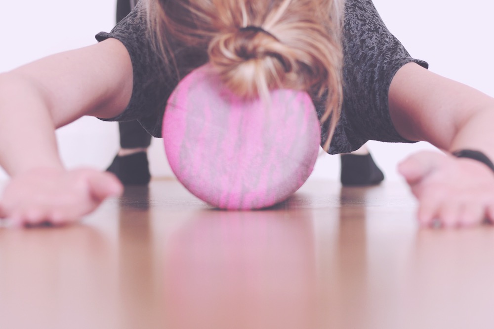 Woman doing Pilates stretches on the foam roller.