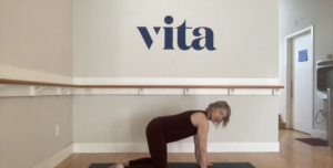 Woman teaching Pilates. She is in a studio.