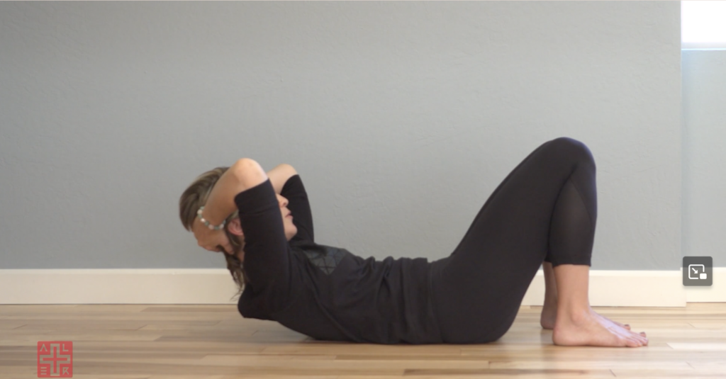 Woman doing Pilates abdominal curl exercises.