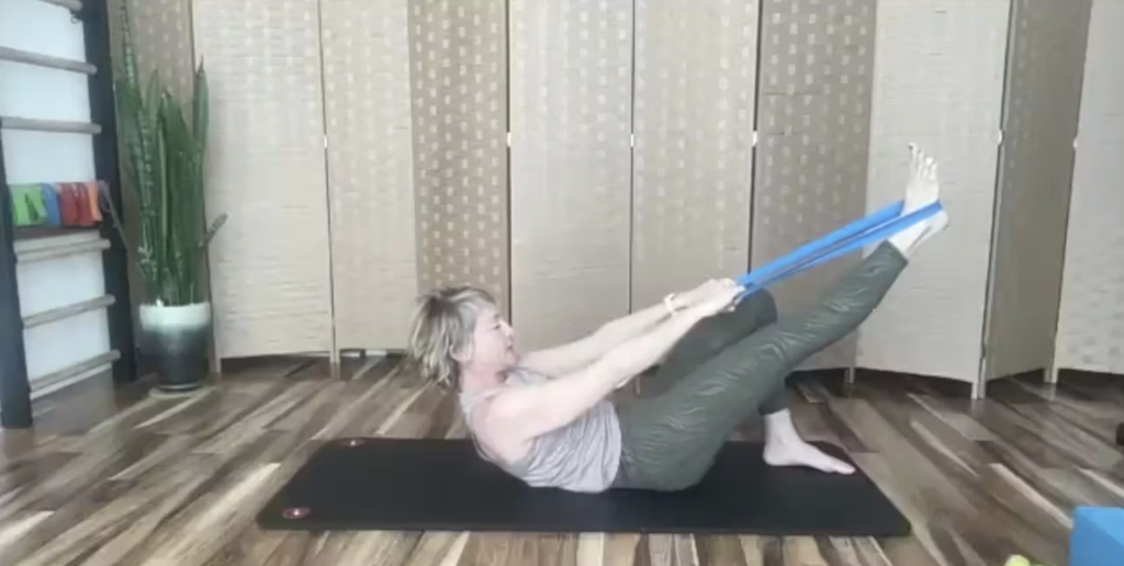 Woman doing Pilates exercises with a loop band.