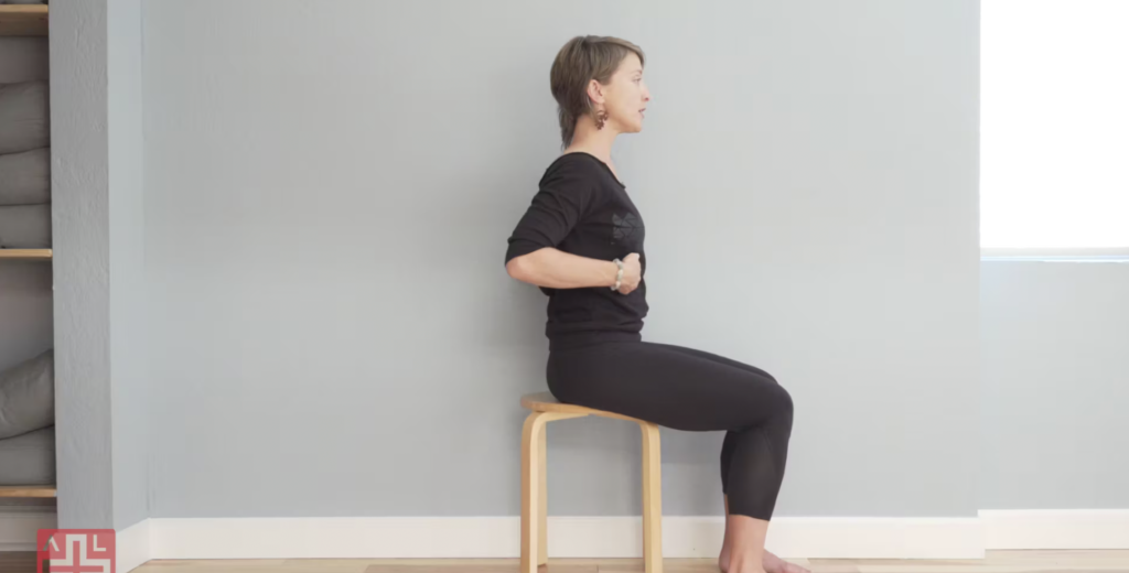 Woman doing Pilates exercises seated.