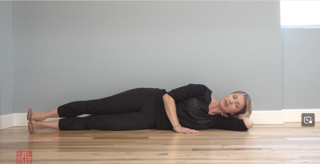 Woman doing Pilates exercises lying on her side.