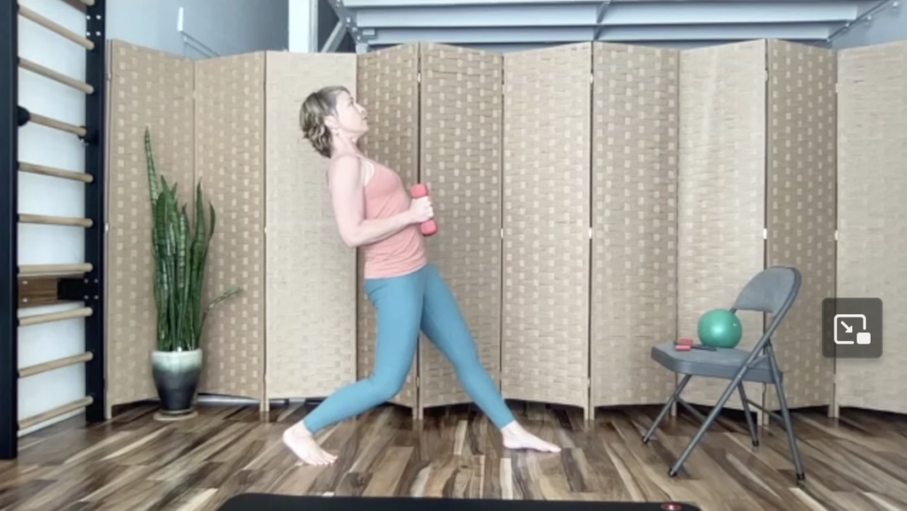 Woman doing Pilates exercises with a chair. She is holding weights.