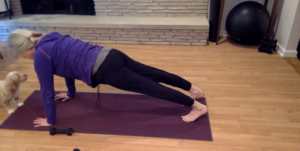 Woman doing a Pilates plank on a yoga mat.