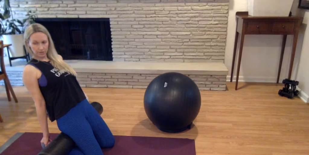 Woman doing Pilates exercises with a foam roller.