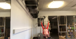 Woman doing Pilates abdominal exercises on the Pilates tower in a Pilates studio.