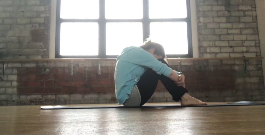 Woman doing Pilates exercises on a yoga mat in a Pilates studio.