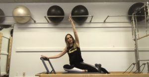 Woman doing Pilates exercises on a Pilates reformer in a Pilates studio.