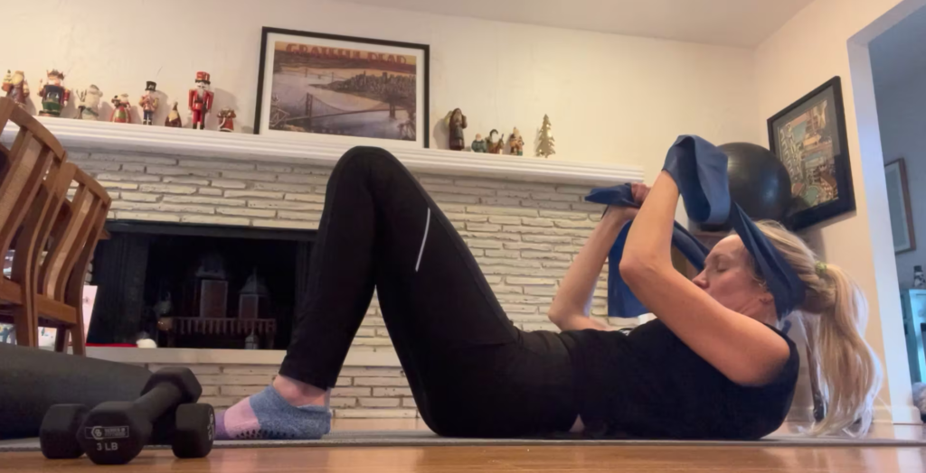 Woman doing Pilates exercises on a yoga mat.