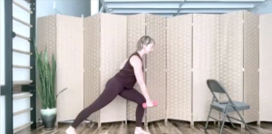 Woman doing Pilates exercises on a yoga mat with a weight.