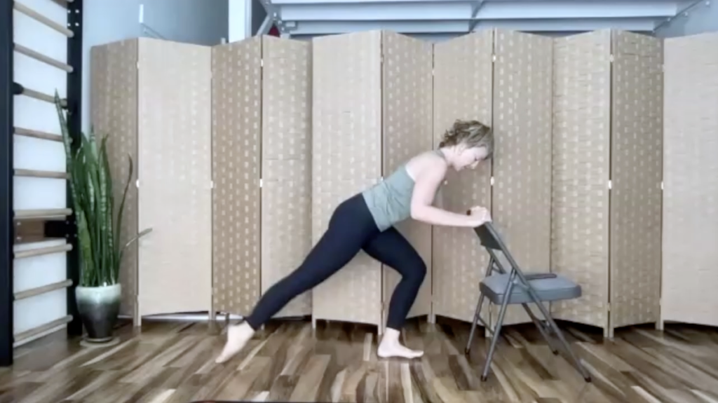 Woman doing Pilates standing with a chair.