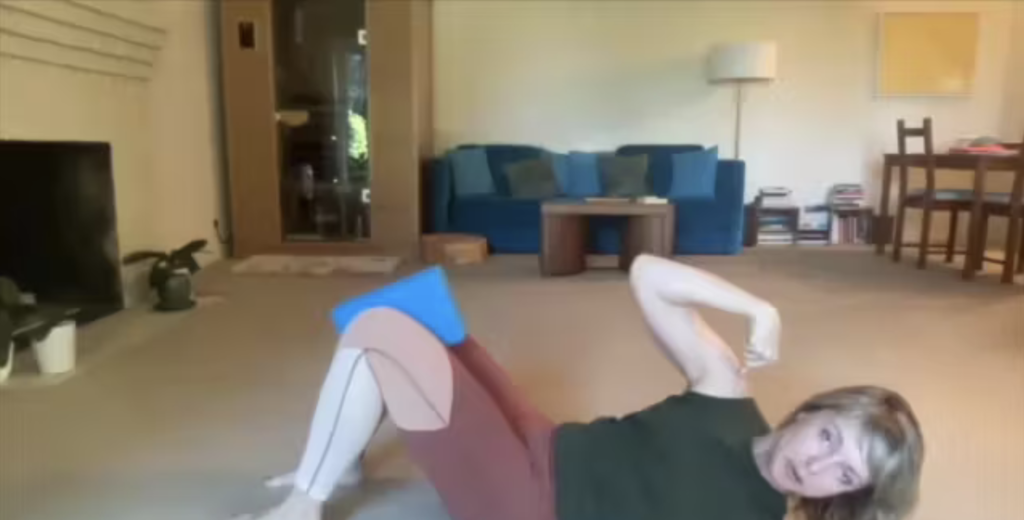 Woman doing Pilates exercises on the floor.