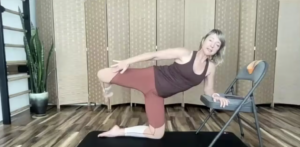 Woman doing Pilates exercises on the Pilates mat with a chair.