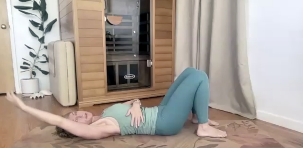 Woman doing Pilates exercises lying on a yoga mat.