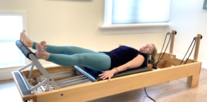 Woman doing Pilates footwork on the Pilates reformer