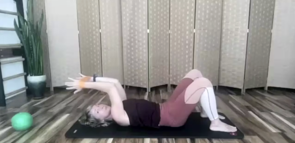 Woman doing Pilates exercises on the floor with loop band for fitness and strength