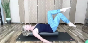 Woman doing Pilates exercises on a Pilates mat on a foam roller.