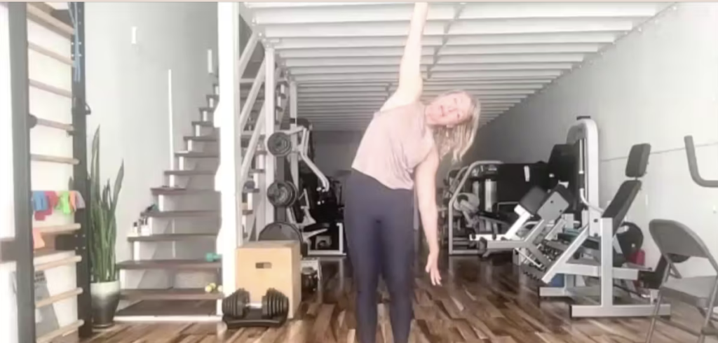 Woman standing doing Pilates exercises and stretching in a gym