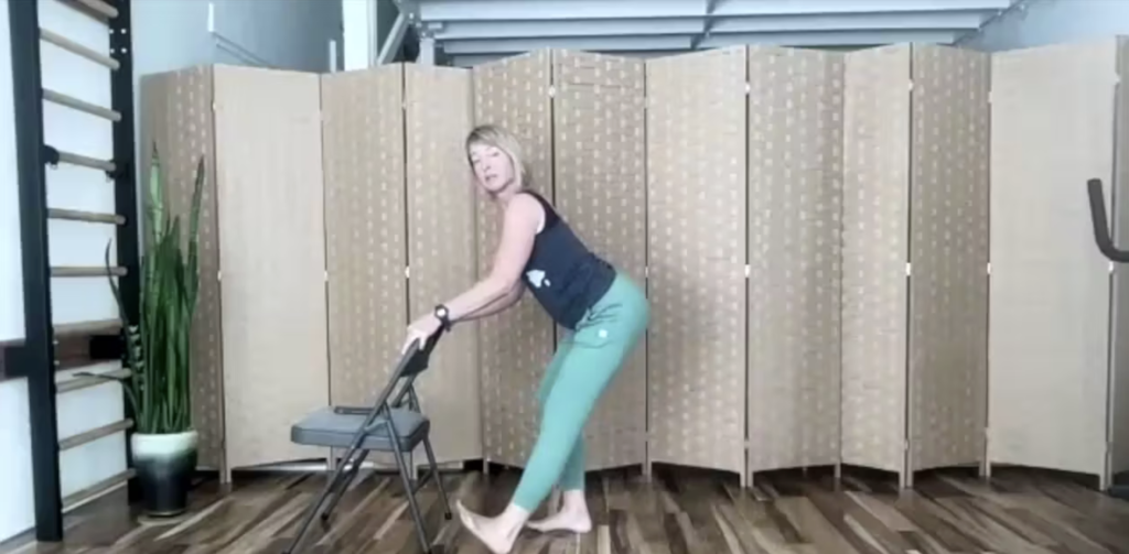 Woman doing Pilates exercises with a chair.