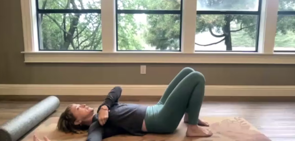 Woman doing Pilates exercises in front of trees on a yoga mat.