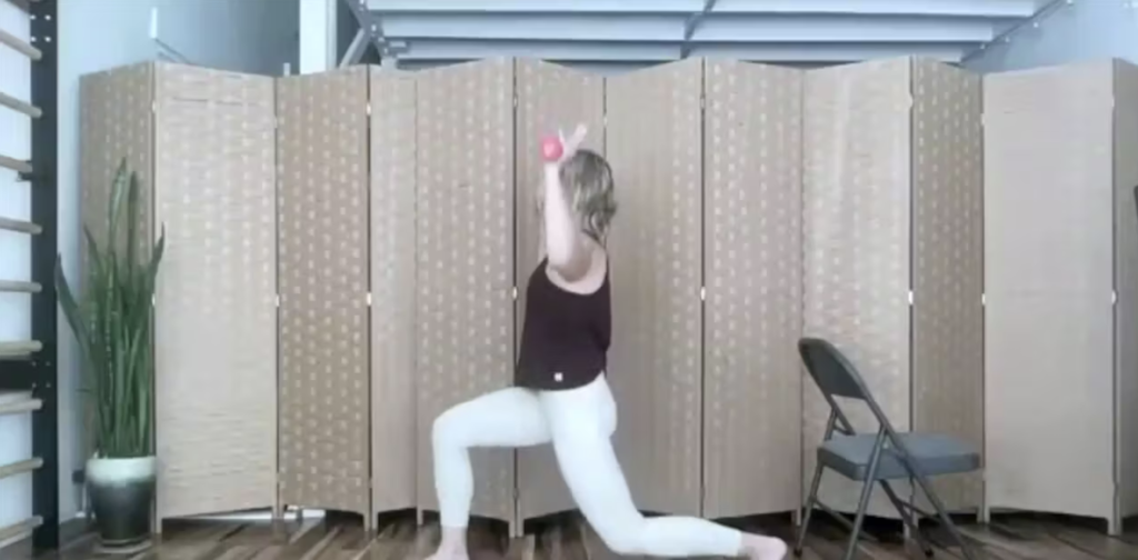 Woman doing Pilates exercises. She is holding weights.