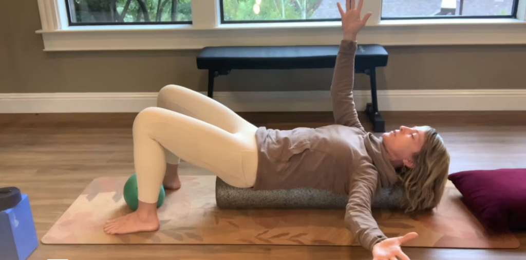 Woman doing Pilates exercises lying on the foam roller.