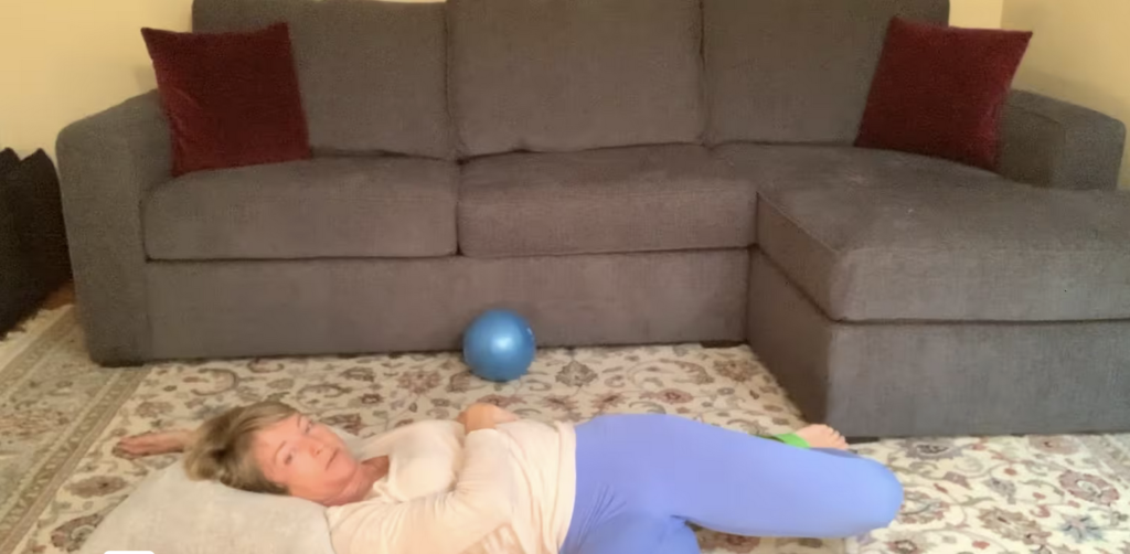 Woman doing Pilates and yoga stretches on the floor.