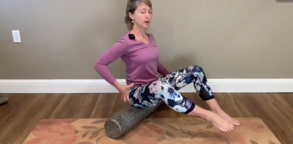 Woman seated on Foam Roller doing Pilates exercises