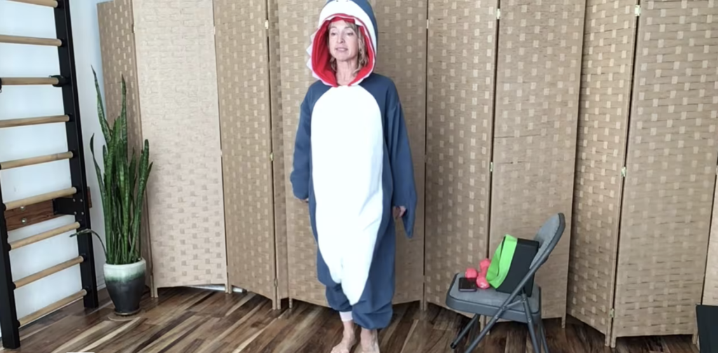 Woman standing in shark costume doing Pilates exercises