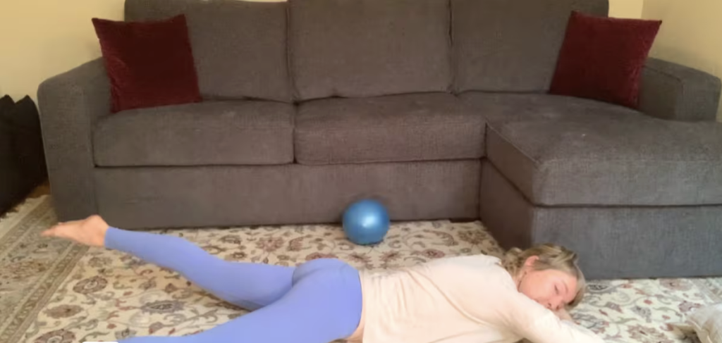 Woman lying on the floor doing Pilates exercises.