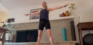 Woman standing doing Pilates abdominal and arm exercises