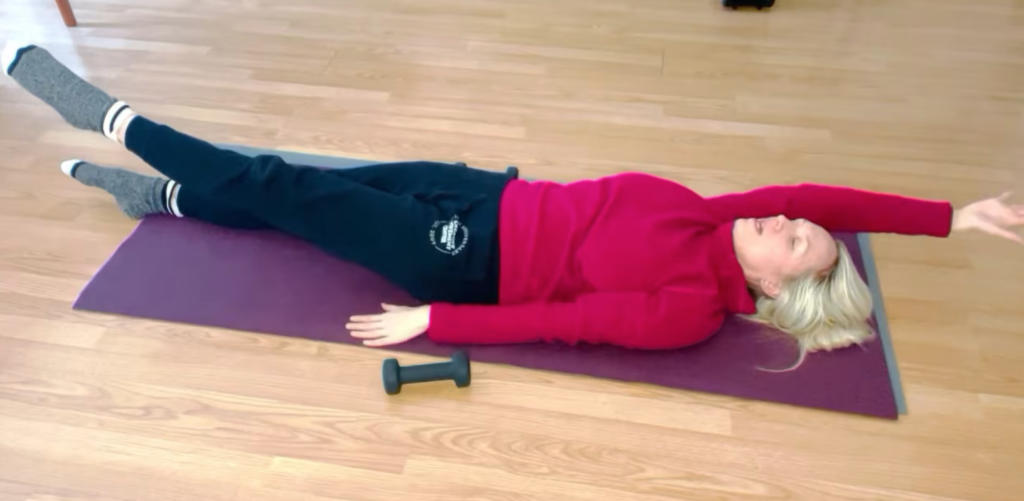 Woman lying on the floor doing Pilates exercises for abdominal muscles