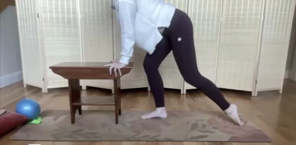 Woman doing a lunge on a Pilates mat.