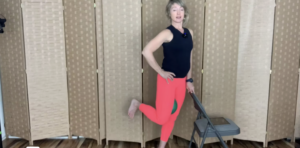 Woman standing doing Pilates and barre exercises with a chair