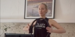 Close up of woman doing Pilates arm work with Magic Circle. Her shirt says Pilates Goddess.