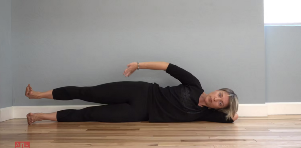 Woman doing Pilates lower body exercises lying on her side