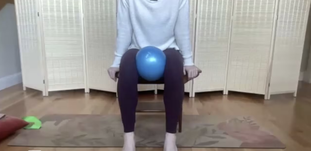 Close up of woman's legs doing Pilates exercises sitting in a chair.