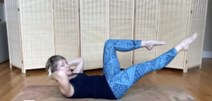 Woman doing Pilates exercises on the Pilates mat with one leg extended.