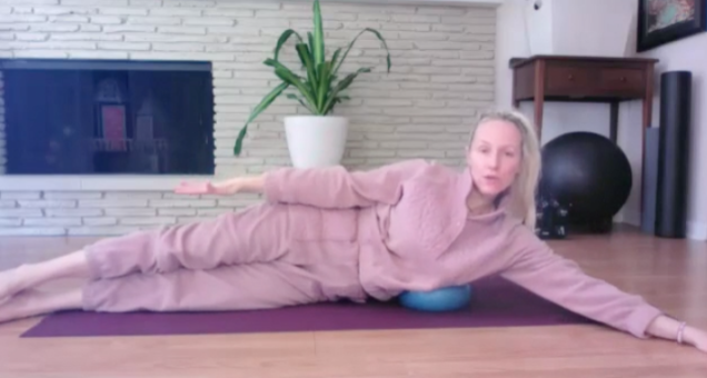 Woman on floor doing Pilates exercises with small ball for waistline