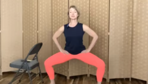 Woman standing doing barre squat exercises for leg strength