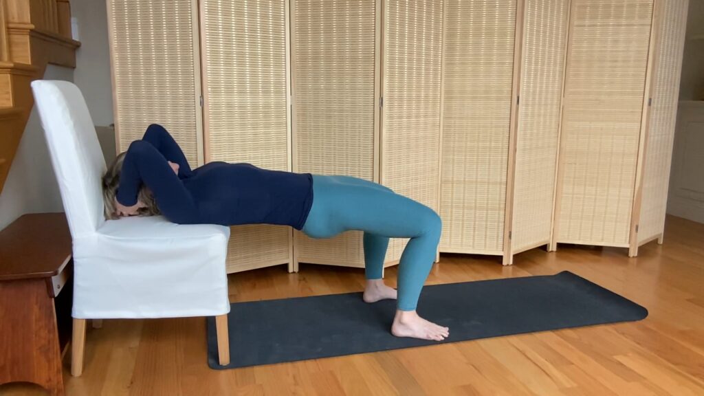 Woman doing Pilates bridging exercises on a chair for fitness and strength