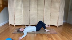 Woman doing Pilates exercises on the floor for stretching lumbar spine